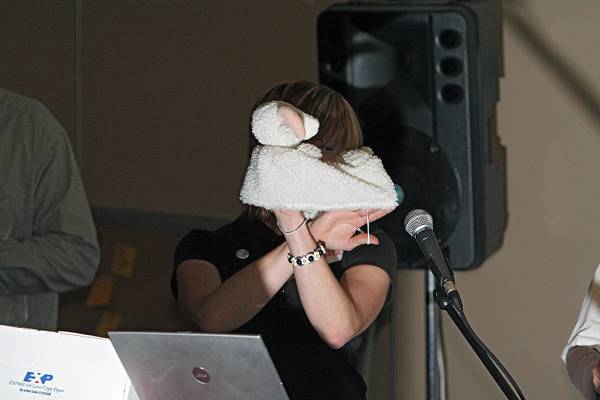 Naomi Andrew, displaying a fabulous sheepskin tissue box cover, a major raffle prize,  | DSTC Farewell Symposium, 28 July 2005  | 